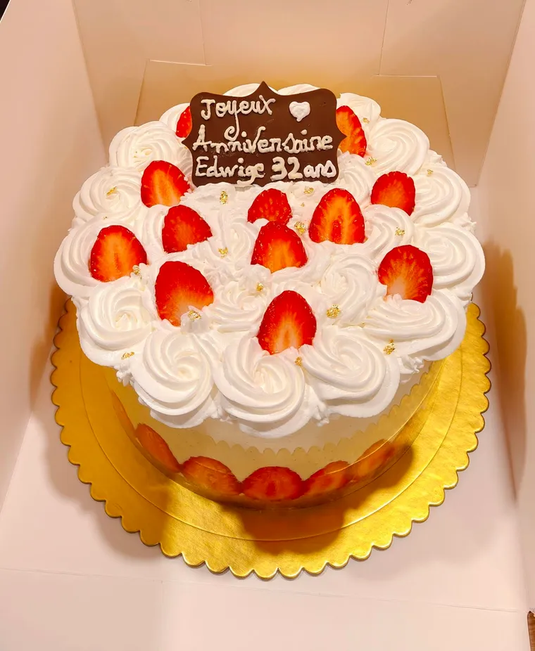 Fraisier couvert de rosaces de crème, fraises fraîches et éclats de feuille d’or